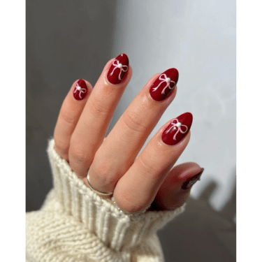 close-up of nails with a burgundy bow design