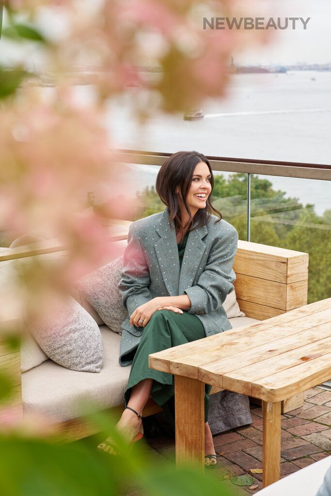 katie lee sitting outdoors in gray blazer