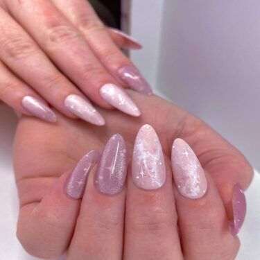 A manicure with soft pink nails and snow flurry nail art