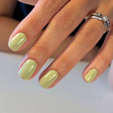 Short nails with a bold green polish.