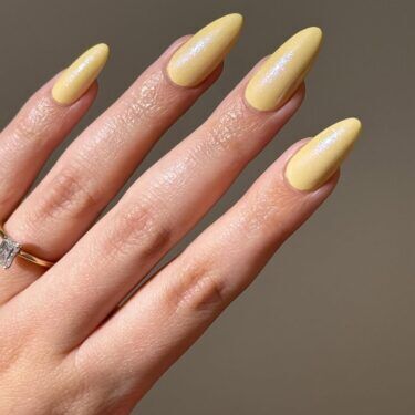 Long nails with a glazed yellow manicure