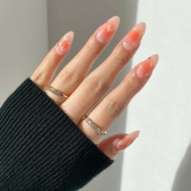 Orange aura nails with hearts and rhinestones