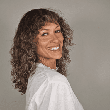 Woman with long curly hair and bangs