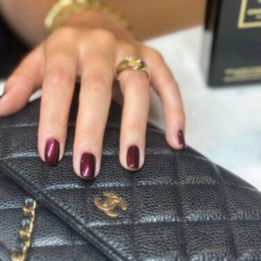 Manicure with dark red polish and shimmer.