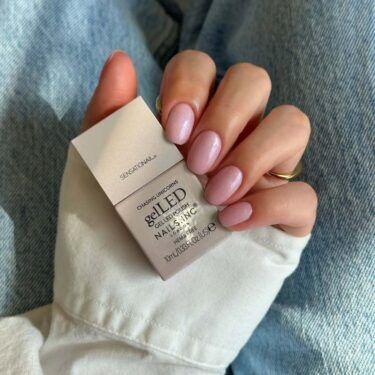 Short nails with shimmery, light pink polish.