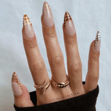 Hand with a French-manicure style, crocodile-themed manicure.