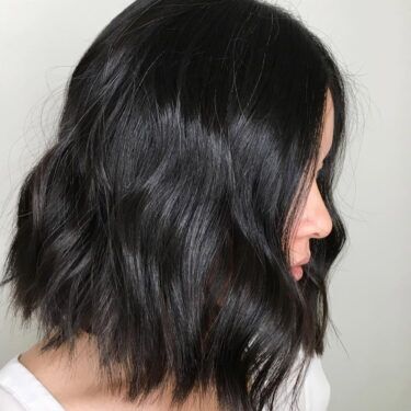 A side profile of a woman's dark asymmetrical bob