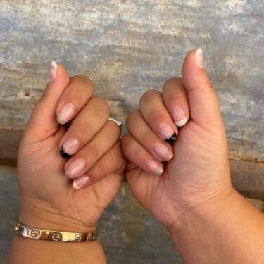 A close up of a woman's hands with her fingers folded to showcase her manicured nails