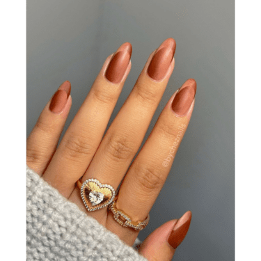 A closeup of a woman's fingers with manicured nails and two rings -- one on the middle finger and one on the pointer finger